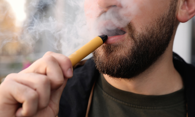 Man using a disposable vape device.